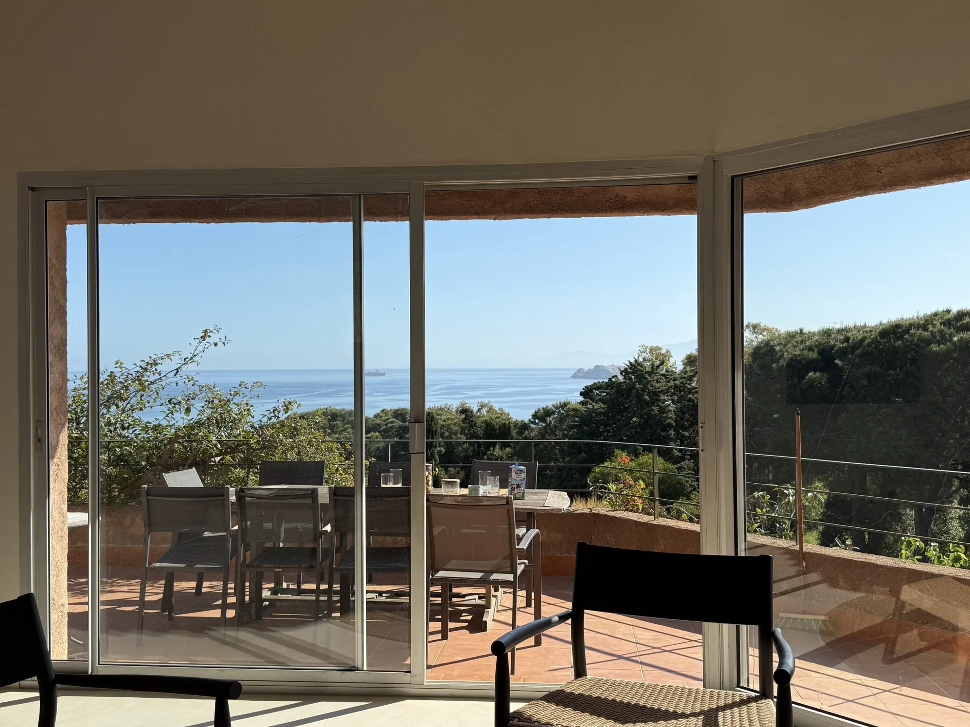 Terrasse couverte avec table de repas et vue sur la mer